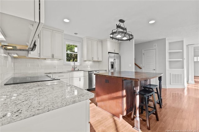 kitchen featuring visible vents, light wood-style flooring, a sink, wood counters, and stainless steel appliances