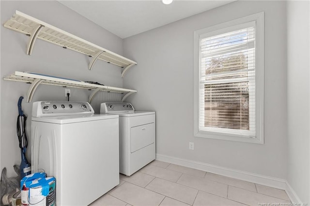 laundry room featuring laundry area, light tile patterned floors, washing machine and dryer, and baseboards