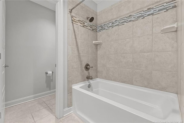 bathroom featuring tile patterned flooring, washtub / shower combination, and baseboards