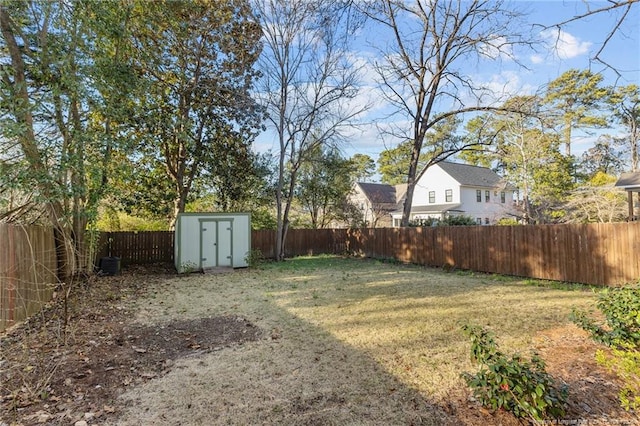 view of yard with an outbuilding, a storage unit, and a fenced backyard