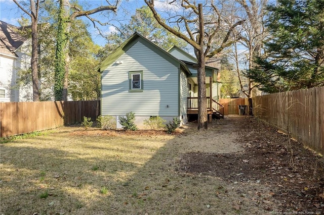 back of property featuring a yard and a fenced backyard