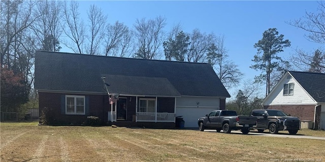 cape cod home with driveway, a front lawn, covered porch, an attached garage, and brick siding