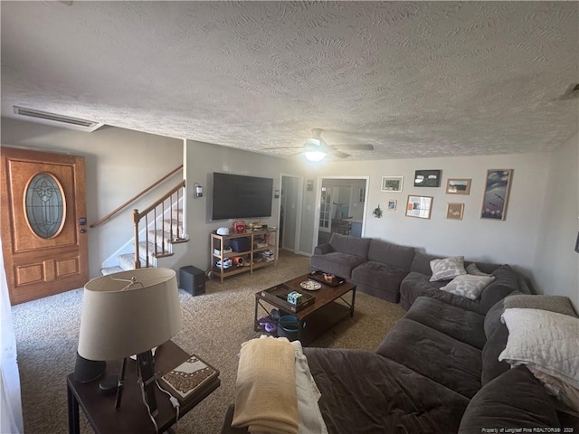 carpeted living area featuring stairs, visible vents, and a textured ceiling