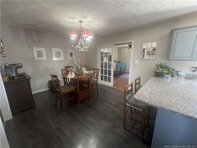 dining area with baseboards, a textured ceiling, an inviting chandelier, and dark wood-style flooring