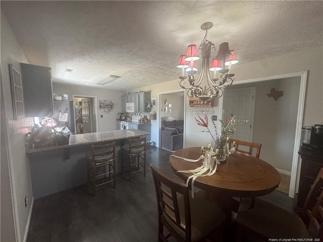 dining area featuring a notable chandelier, dark wood-style flooring, and a textured ceiling