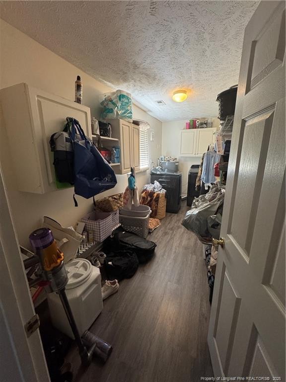 laundry area featuring a textured ceiling and wood finished floors