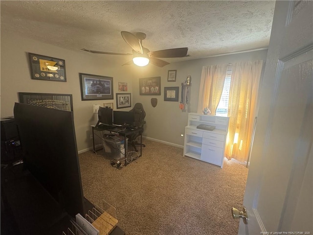 carpeted office featuring a ceiling fan, baseboards, and a textured ceiling