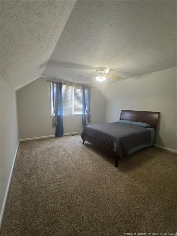 carpeted bedroom featuring lofted ceiling, baseboards, and a textured ceiling