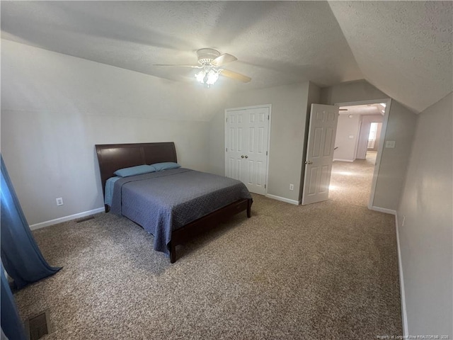 bedroom featuring baseboards, lofted ceiling, a textured ceiling, and carpet