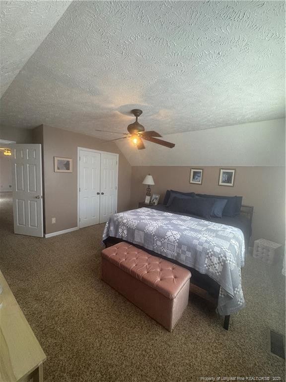 carpeted bedroom featuring baseboards, ceiling fan, vaulted ceiling, a closet, and a textured ceiling