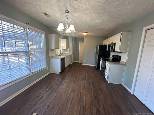 kitchen featuring visible vents, dark wood-type flooring, a sink, stainless steel appliances, and baseboards