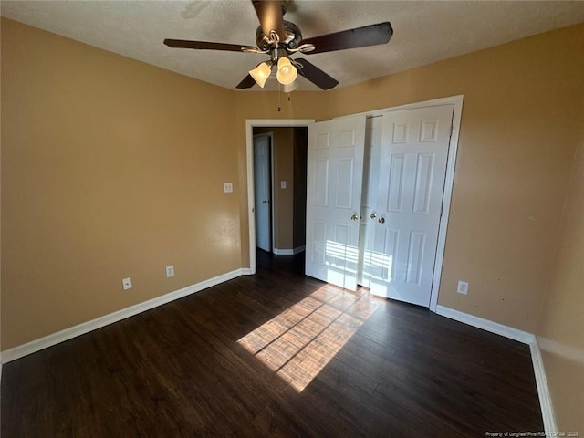 unfurnished bedroom with baseboards, dark wood-style flooring, a closet, and a textured ceiling