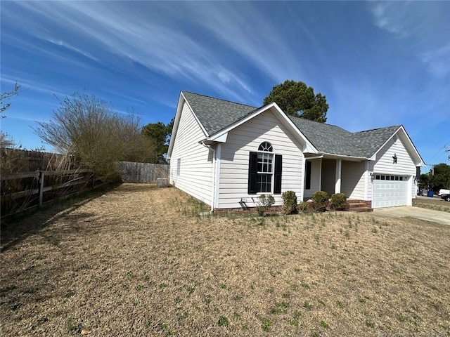 view of front of home featuring fence, driveway, roof with shingles, an attached garage, and a front lawn