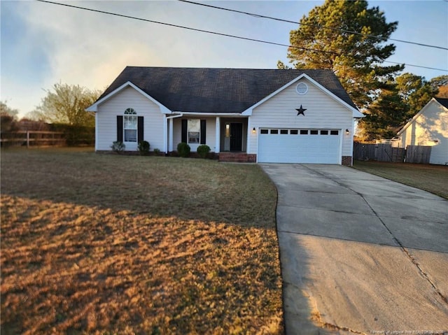 ranch-style home featuring a front lawn, an attached garage, driveway, and fence