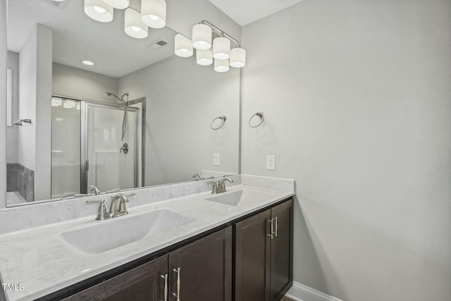 bathroom featuring double vanity, visible vents, a stall shower, and a sink