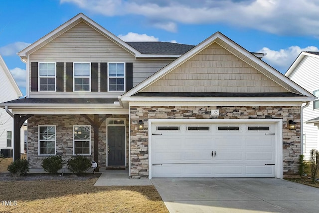 view of front of house with stone siding, cooling unit, driveway, and a garage