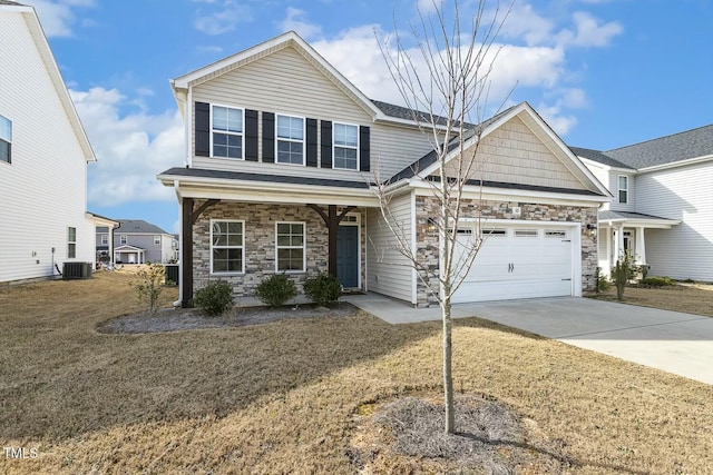 view of front of property featuring central air condition unit, stone siding, concrete driveway, a front yard, and an attached garage