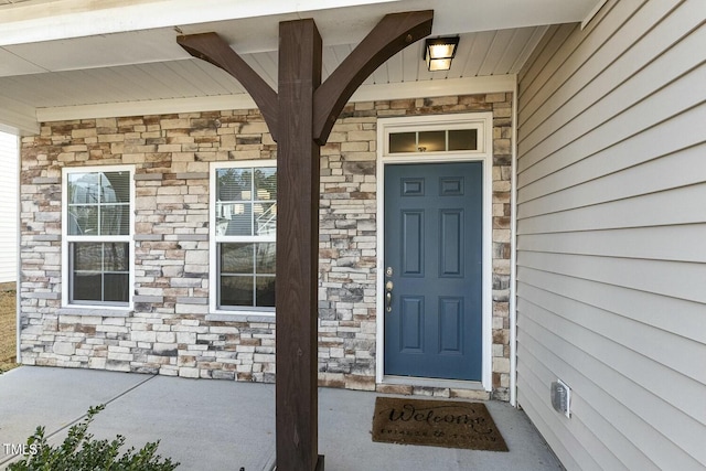 property entrance featuring stone siding and a porch