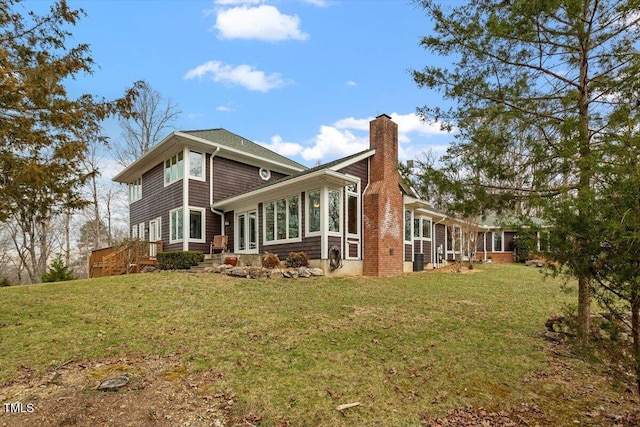 back of house with a lawn and a chimney