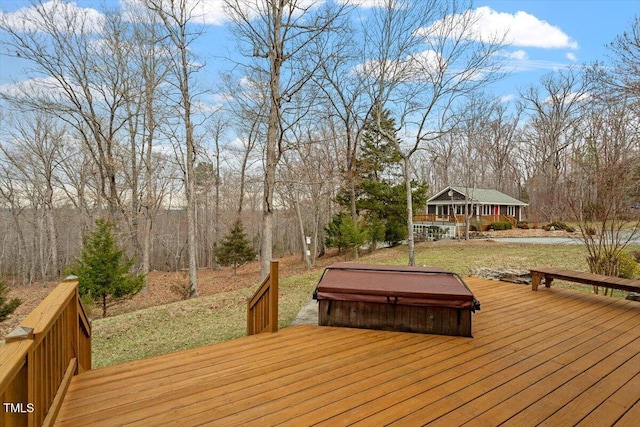 wooden terrace with a covered hot tub and a lawn