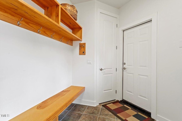 mudroom featuring baseboards and dark tile patterned flooring