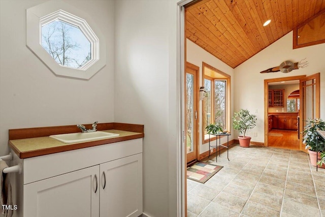 bathroom featuring wooden ceiling, baseboards, a wealth of natural light, and vaulted ceiling