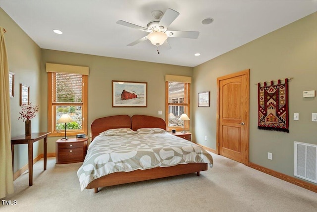 bedroom with visible vents, light carpet, and baseboards