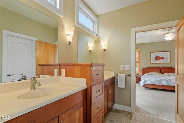 ensuite bathroom with connected bathroom, tile patterned flooring, baseboards, ceiling fan, and vanity