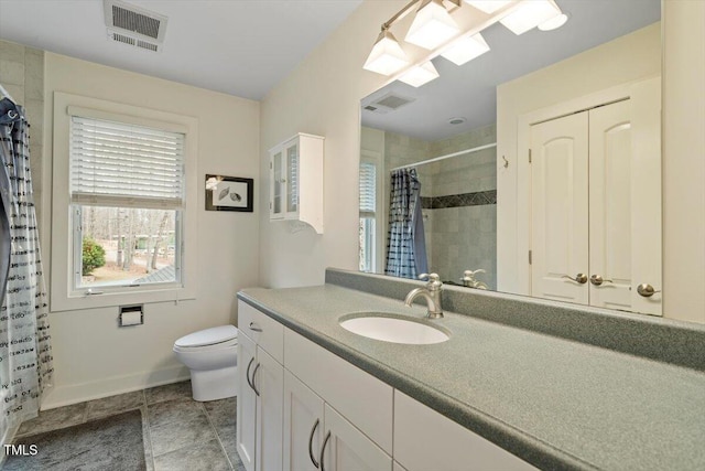 bathroom with vanity, baseboards, visible vents, a tile shower, and toilet