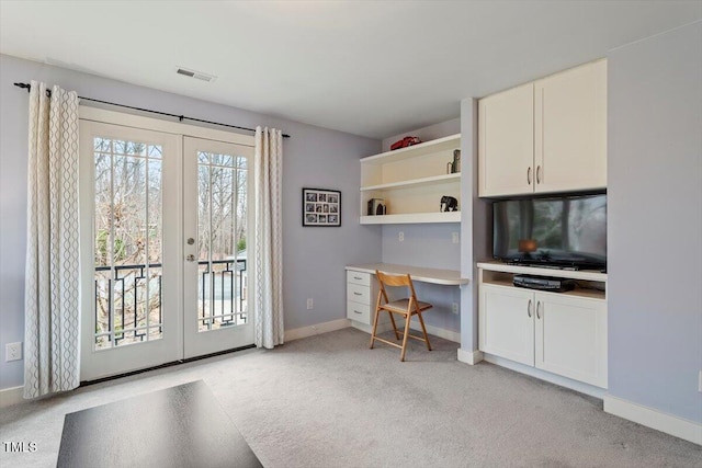 office area featuring built in desk, light colored carpet, french doors, and visible vents