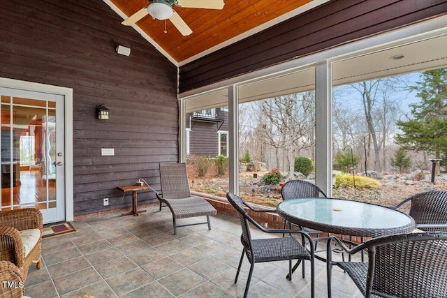 sunroom / solarium with plenty of natural light, lofted ceiling, and ceiling fan