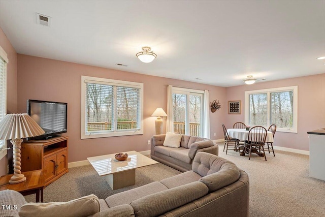 carpeted living area featuring visible vents and baseboards