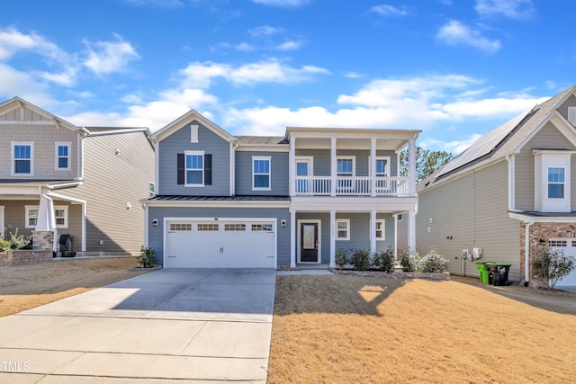 view of front of house featuring an attached garage, metal roof, a balcony, driveway, and a standing seam roof