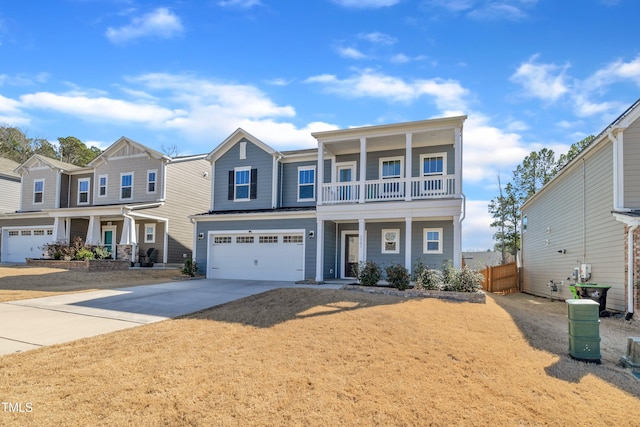 view of front of home with an attached garage, fence, covered porch, a balcony, and driveway