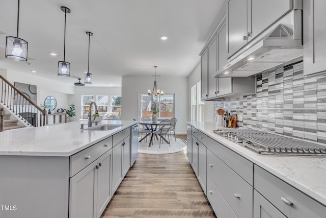 kitchen with under cabinet range hood, appliances with stainless steel finishes, gray cabinetry, and a sink