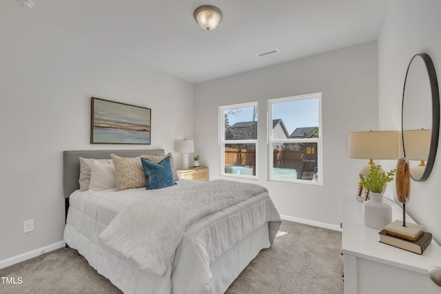 carpeted bedroom with visible vents and baseboards