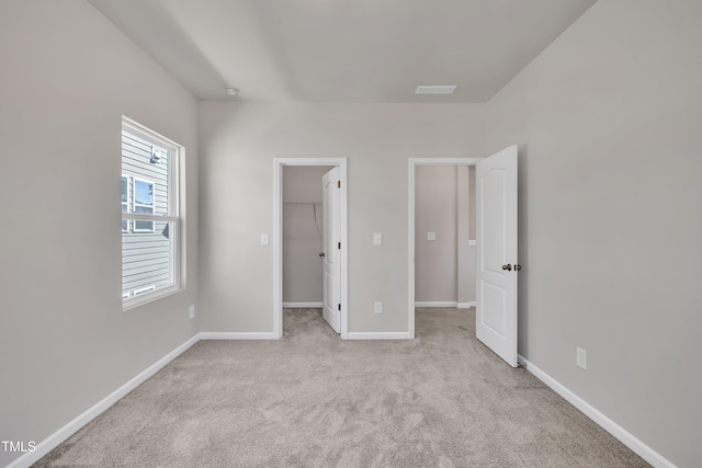 unfurnished bedroom with baseboards, carpet floors, visible vents, and a spacious closet