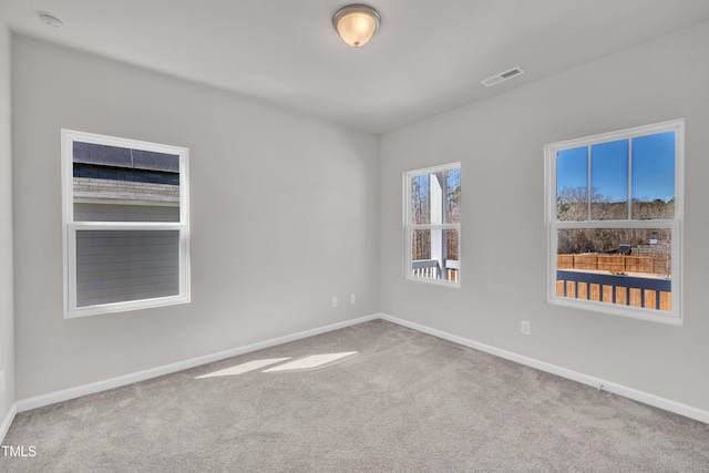 unfurnished room featuring baseboards, visible vents, and carpet floors