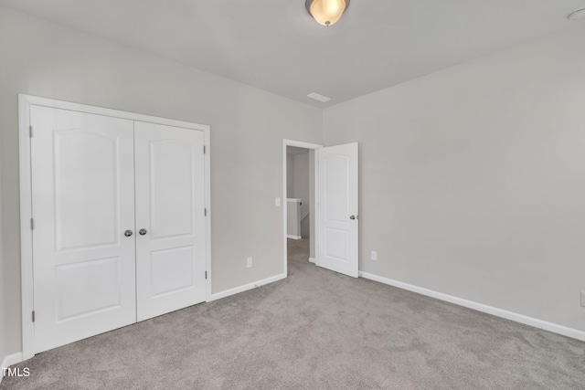 unfurnished bedroom with a closet, visible vents, baseboards, and carpet