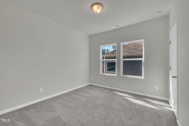 carpeted empty room featuring visible vents and baseboards