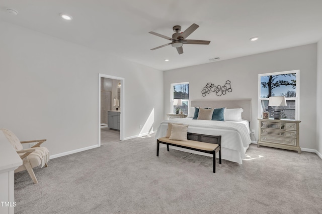 bedroom with visible vents, baseboards, light colored carpet, recessed lighting, and ensuite bath