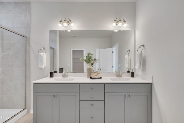 full bathroom featuring a shower stall, double vanity, and a sink