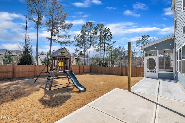 view of playground featuring a patio area, a fenced backyard, and a sunroom