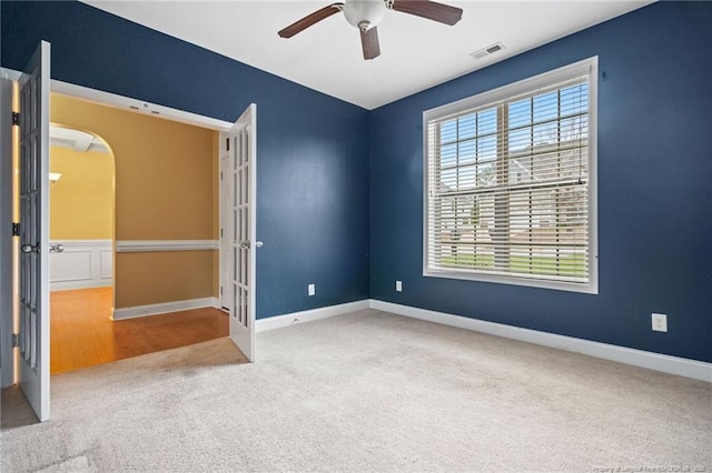 unfurnished bedroom featuring visible vents, baseboards, arched walkways, french doors, and carpet flooring