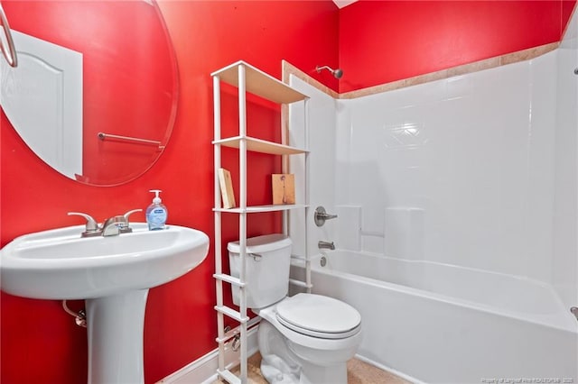 bathroom with a sink, shower / bathing tub combination, baseboards, and toilet