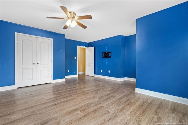 unfurnished bedroom featuring a closet, baseboards, and wood finished floors