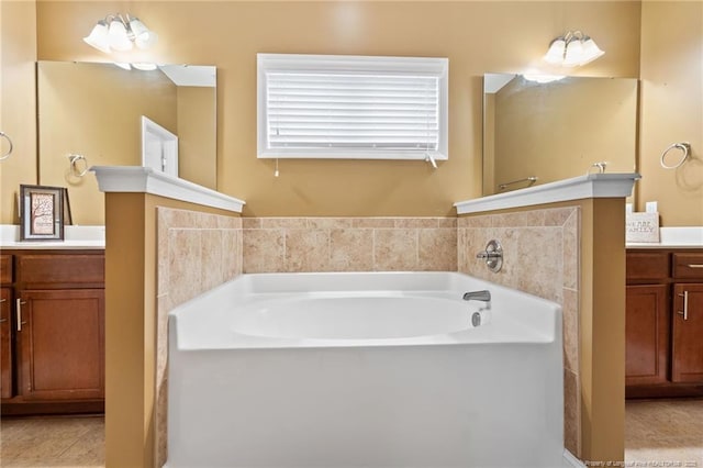 bathroom featuring tile patterned floors, a garden tub, and vanity