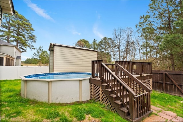 view of swimming pool with a fenced backyard, a fenced in pool, a deck, and stairs