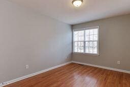 spare room with wood finished floors and baseboards