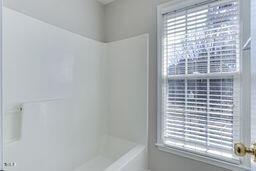 full bath featuring a shower and a tub to relax in